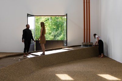 Two people standing on a flow of water running through a gallery.