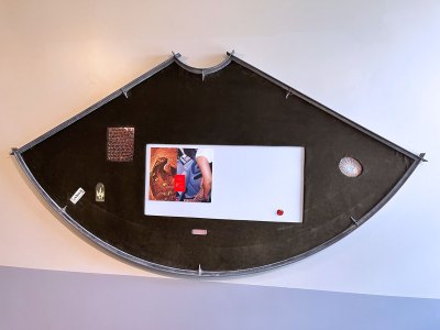 A pile of metal inlays with pictures of two arms.