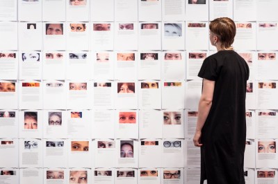 A woman looks at people's eyes above the text print.