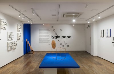 View of sculpture exhibition in gallery, title of back wall and wall text.