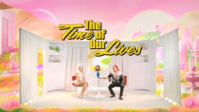 The title screen of a movie shows two people wearing Barbie-like sets. 