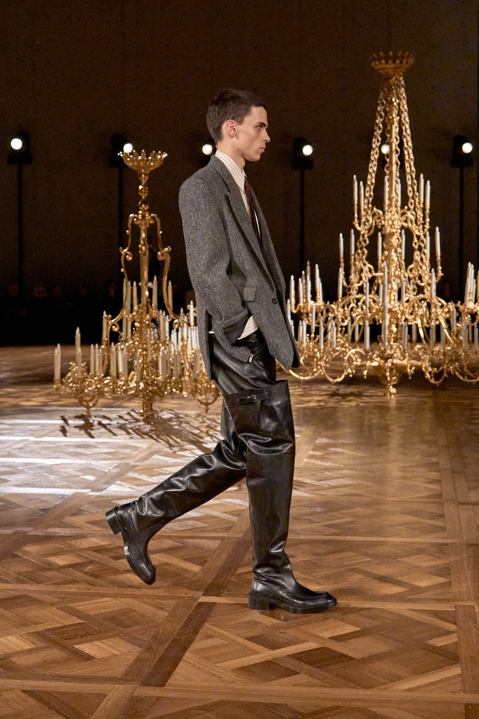 Image may contain Chandelier Lamp Lighting Adult Person Clothing Footwear Shoe Formal Wear Suit and Performer