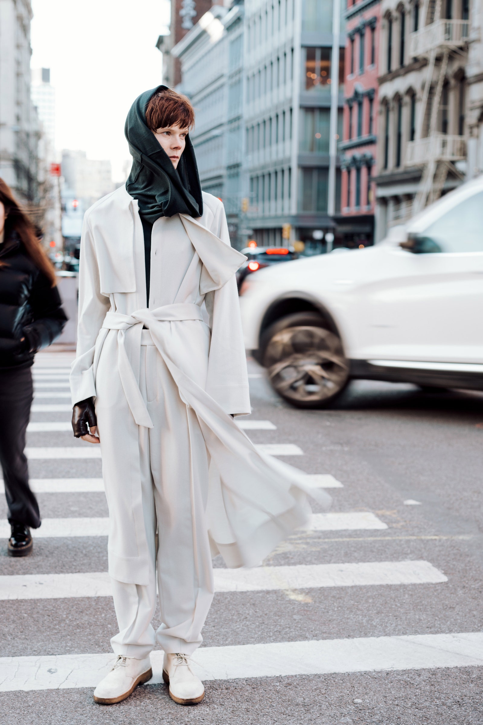 Image may contain Pedestrian Person Clothing Coat Adult Car Transportation Vehicle Standing and Road