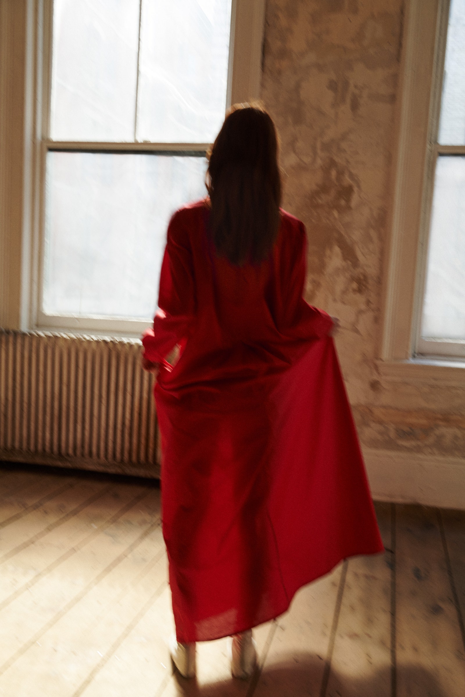 Image may contain Fashion Adult Person Floor Flooring Clothing Dress Coat Wood Footwear and Shoe