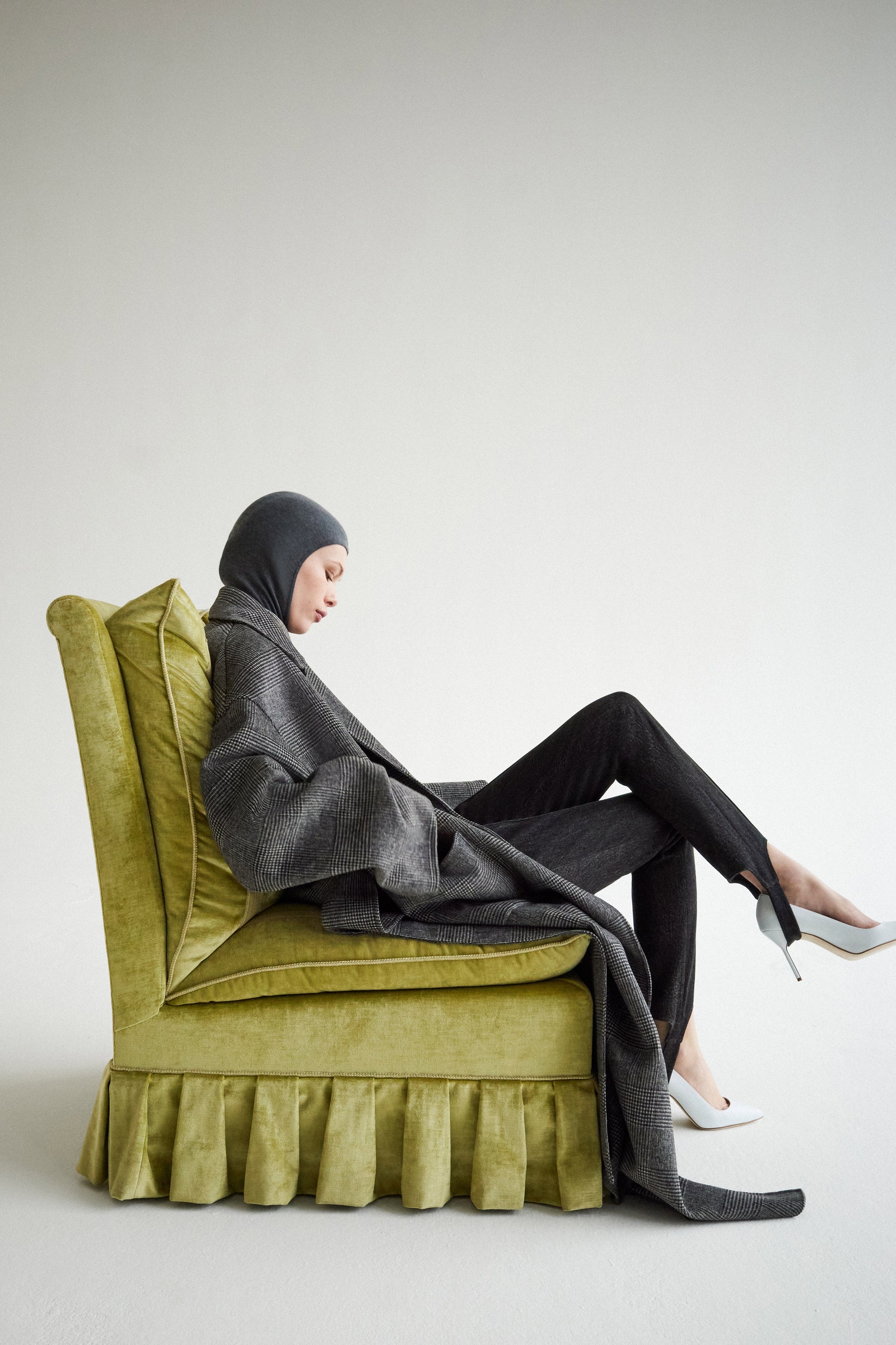 Image may contain Adult Person Sitting Furniture Clothing Footwear High Heel Shoe and Chair