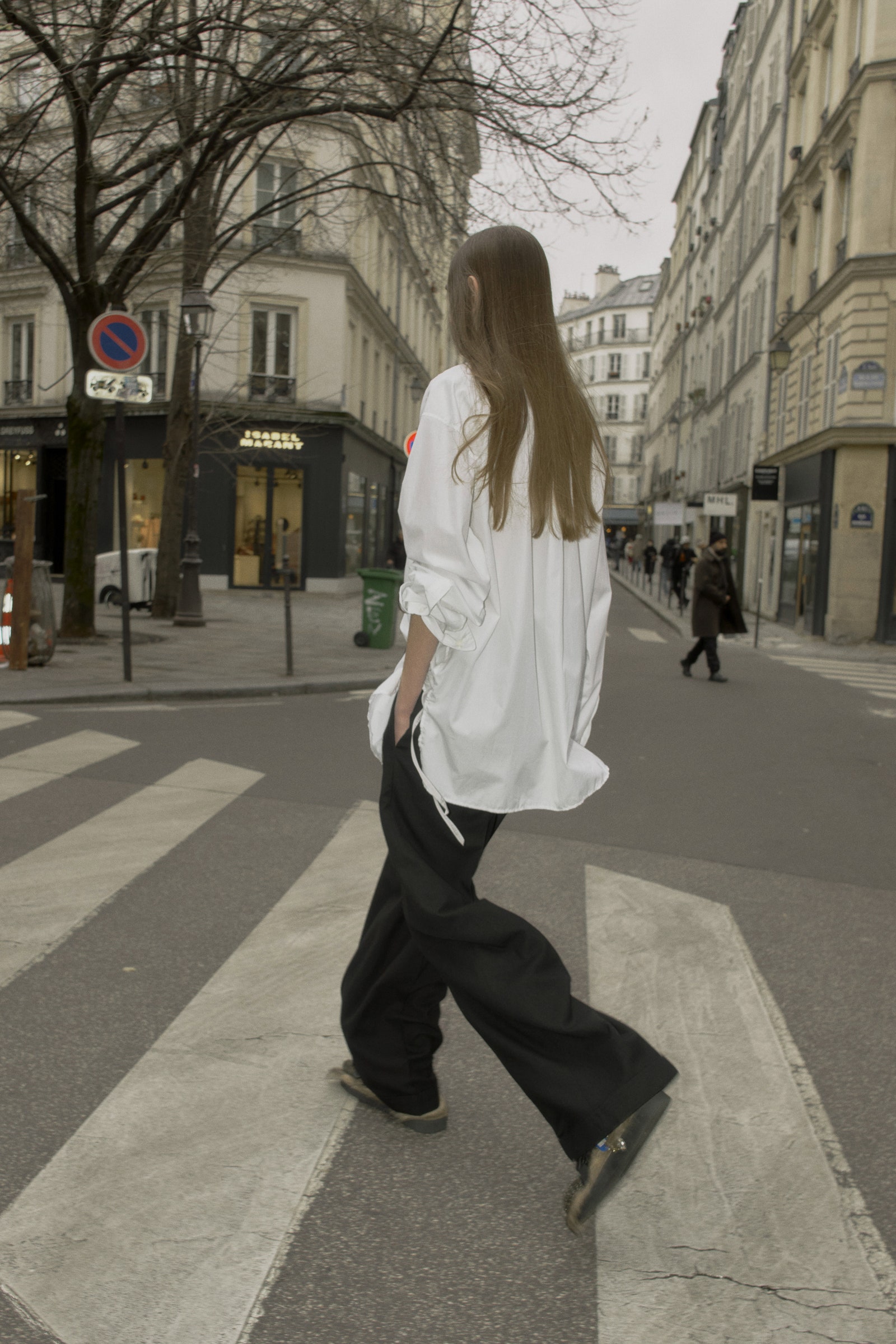 Image may contain Pedestrian Person Walking Road Clothing Footwear Shoe Pants Teen Tarmac City and Accessories