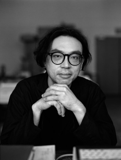A man in glasses looks at the camera.
