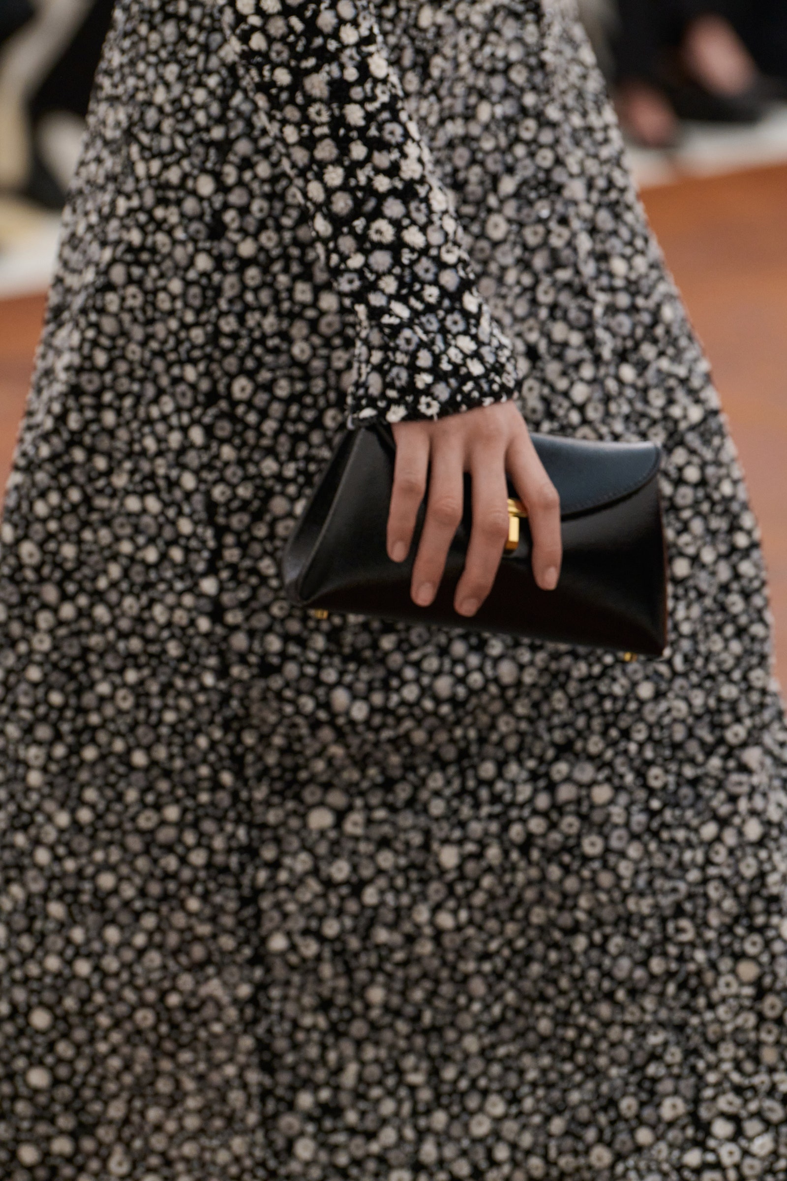 Image may contain Adult Person Clothing Dress Fashion Formal Wear Long Sleeve Sleeve Accessories Wallet and Gown