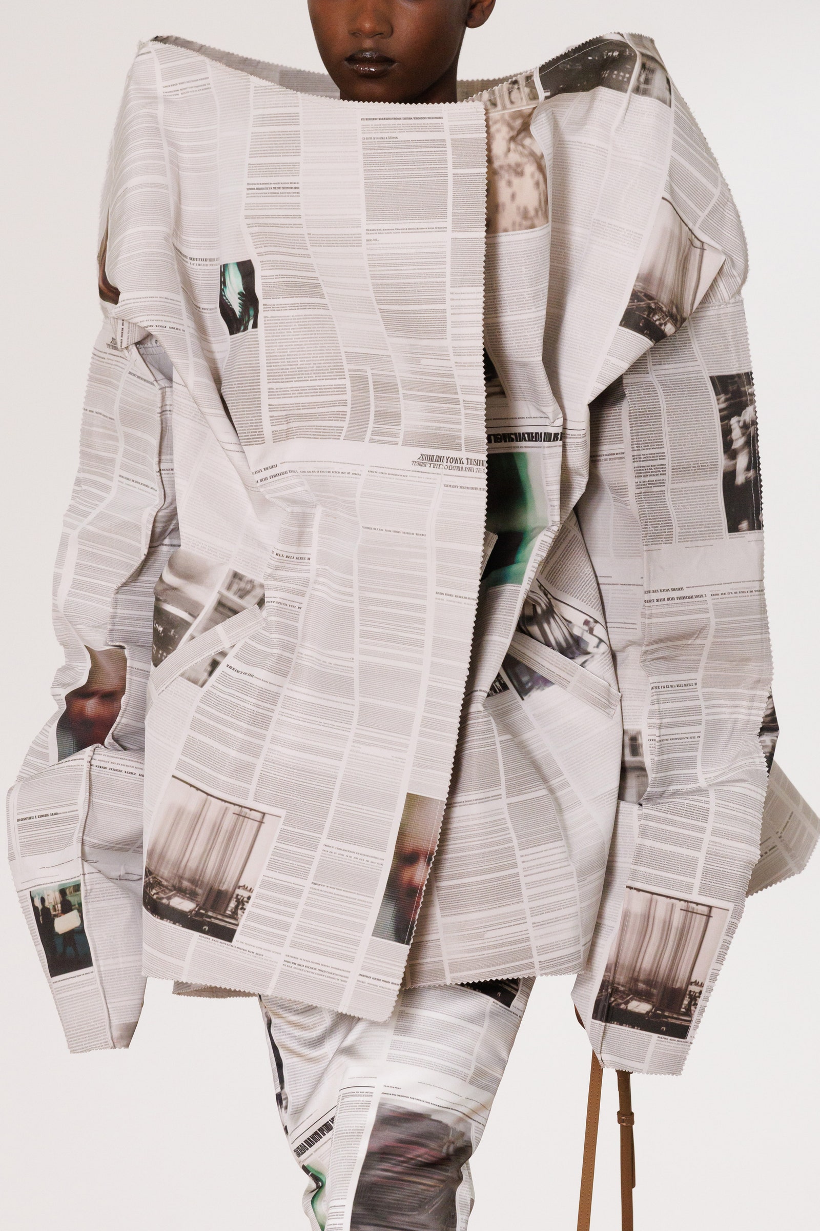 Image may contain Clothing Coat Formal Wear Text Long Sleeve Sleeve and Person