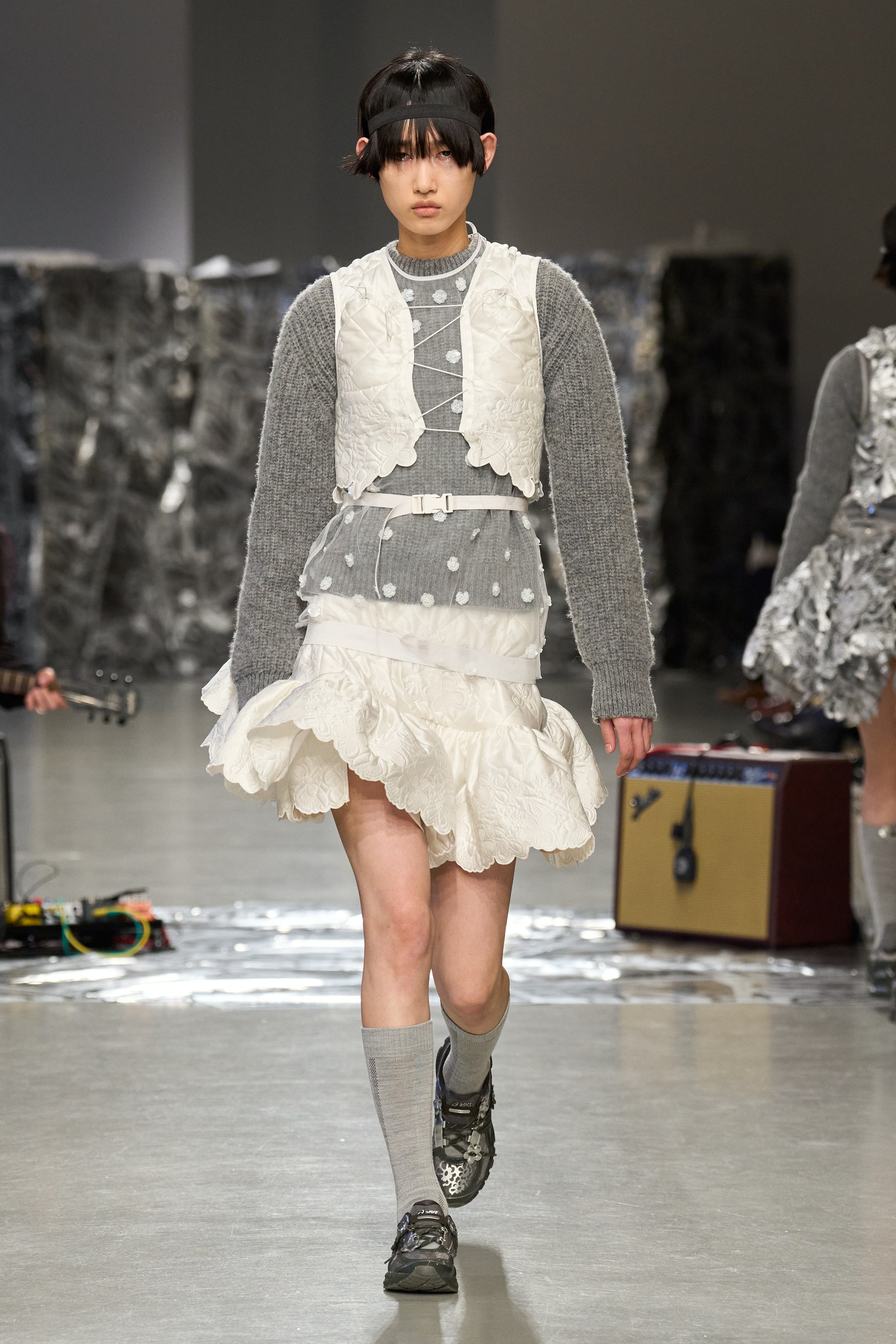 Image may contain Person Fashion Adult Clothing Footwear Shoe Long Sleeve Sleeve Skirt Box and Guitar