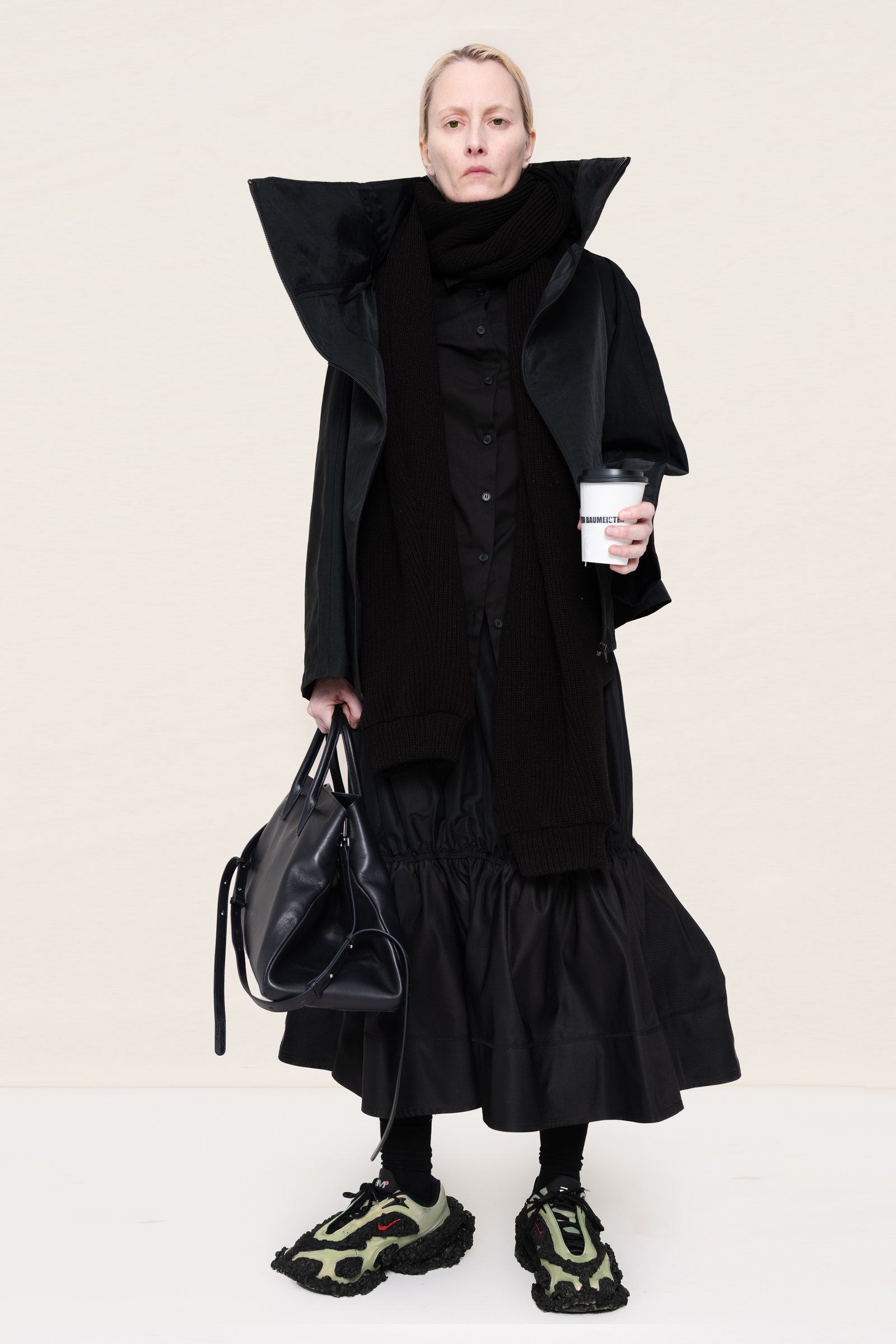 Image may contain Clothing Coat Fashion Adult Person Footwear Shoe Accessories Bag Handbag Cape Overcoat and Cup