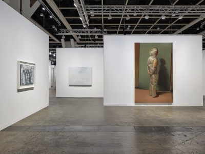 View of an art fair stall with three paintings on three different walls. 