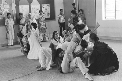 A black and white photo is a woman dancing in a group.