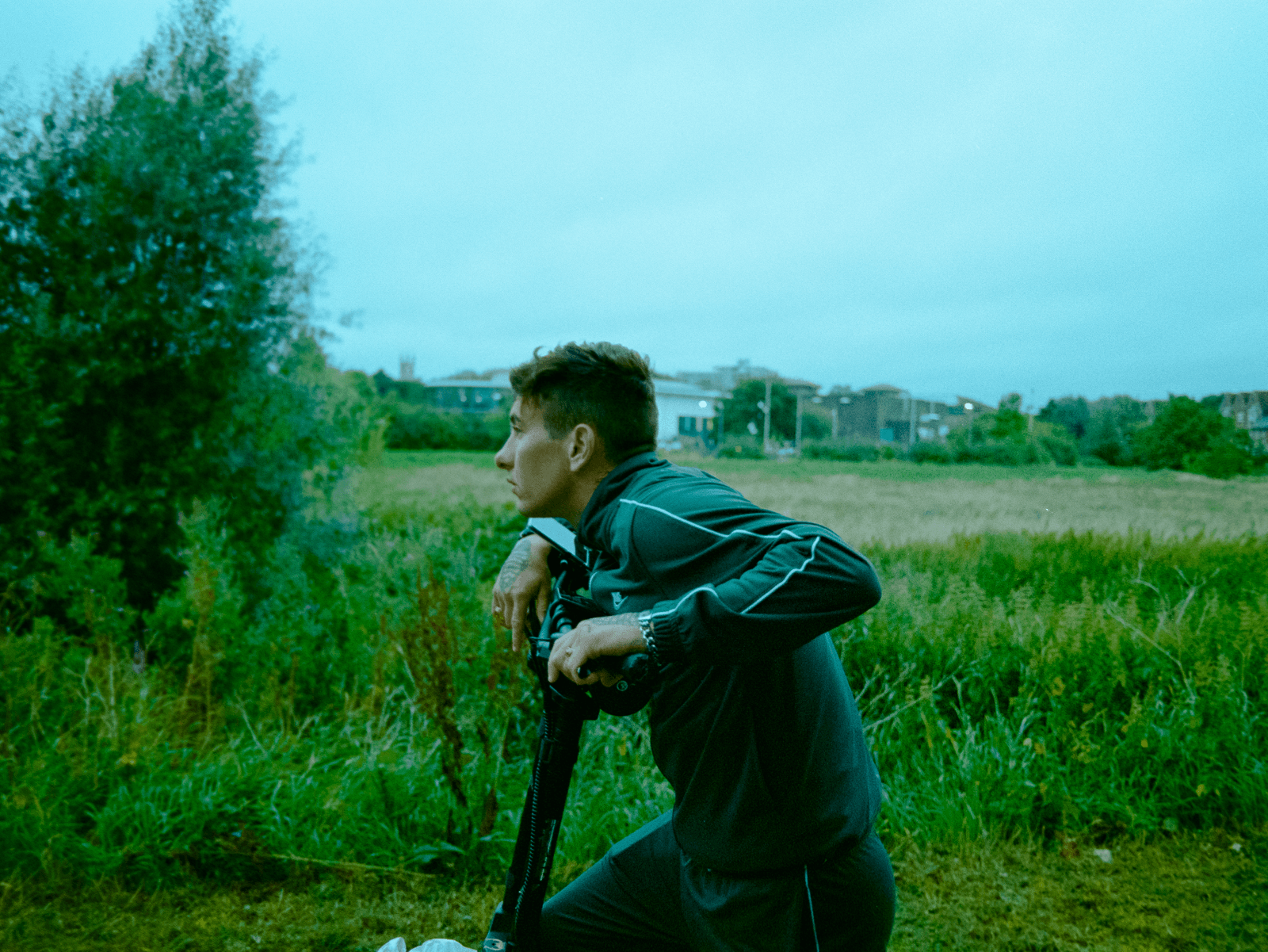 Images may contain photography grass plants adult guns weapons photographer face and portrait