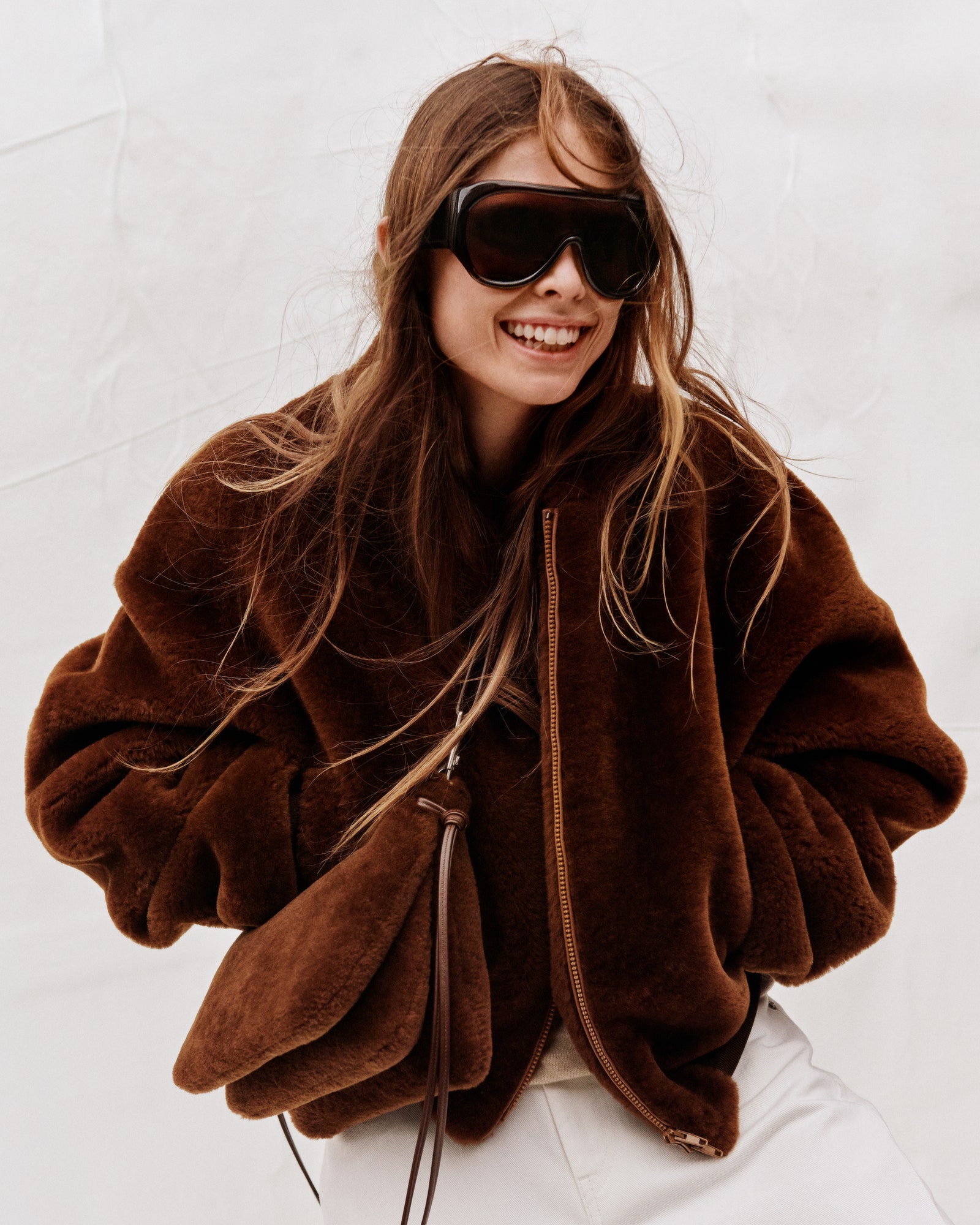 Image may contain clothes coat adult jacket face happy head smile accessories glasses and photography