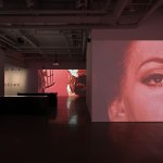 View of the art gallery displays video on different walls.