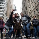 People are placed next to the bronze sculpture.