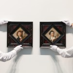 Two people were holding two amazing paintings.