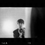A handsome young man taking a picture in the mirror.