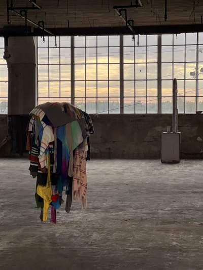An art installation showing a bunch of clothes mounted on a clothesline. 