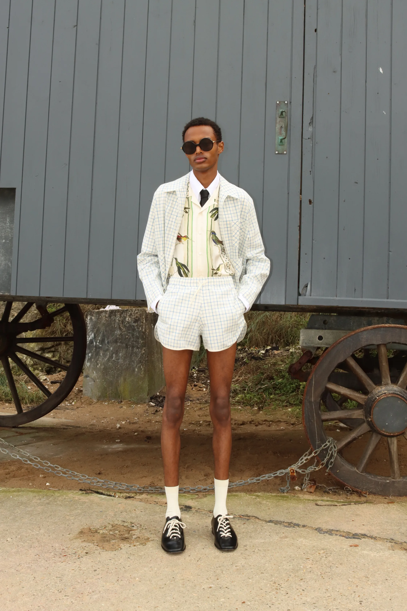 Image may contain people standing in shorts with clothes and wheels talking formally wearing teen coats footwear and shoes
