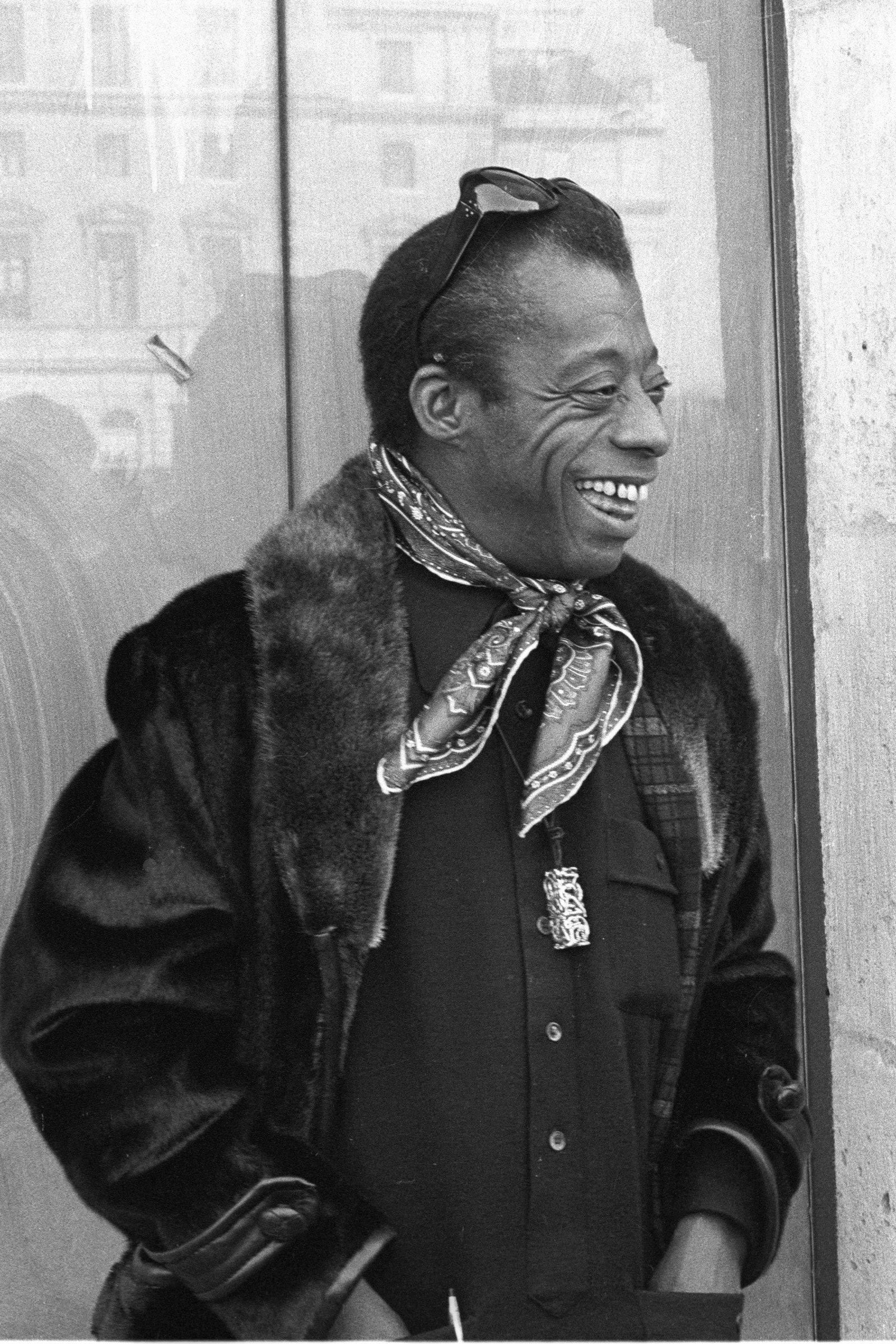 Images may contain James Baldwin head man face photography portrait clothing jacket happy smile and adult