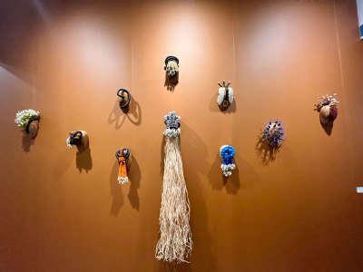 A base of carved wood is affixed with different combinations of lagdibá beads, cowrie shells, glass beads, copper, silver, and straw, among other materials.