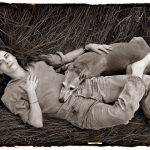 Photographer Sally Mann relaxes with dog honey on the highland grass on a farm near Lexington, Virginia.