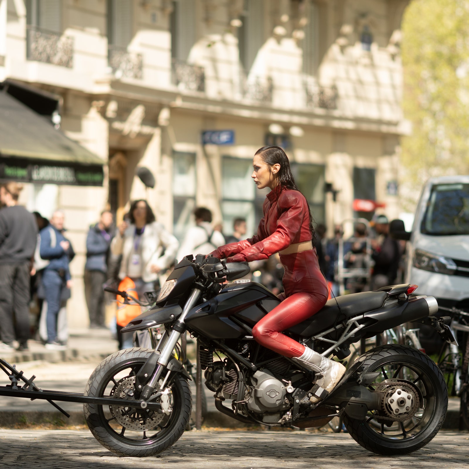 Bella Hadid was found in Paris wearing a striking red bike outfit while filming a fierce action scene.