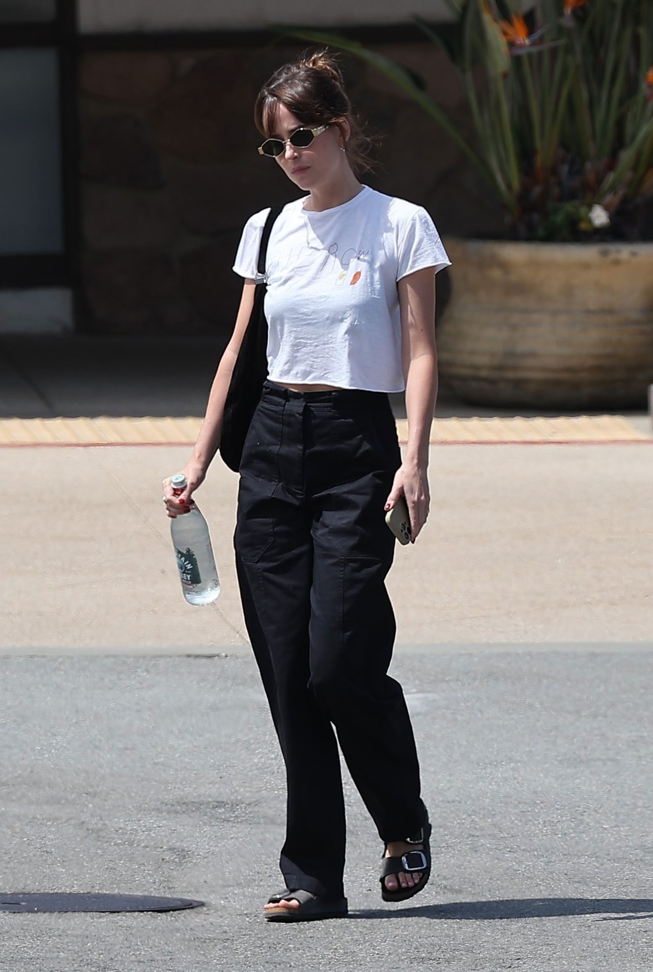 Images may contain Dakota Johnson Clothing Pants Pedestrian Teen Accessories Glasses Bags and Totes