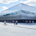A wide museum building, people stand in front of it.