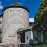 A cylindrical tower with a tower with an entrance protruding.