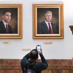 Denver, March 24: A visitor took a portrait of President Donald Trump, right, hanging on the wall of the rotunda on the third floor of Denver, Colorado, March 24, 2025. The board of directors painted a portrait of Trump in 2019.