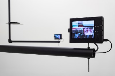A small monitor showing a group of people attached to metal rods.