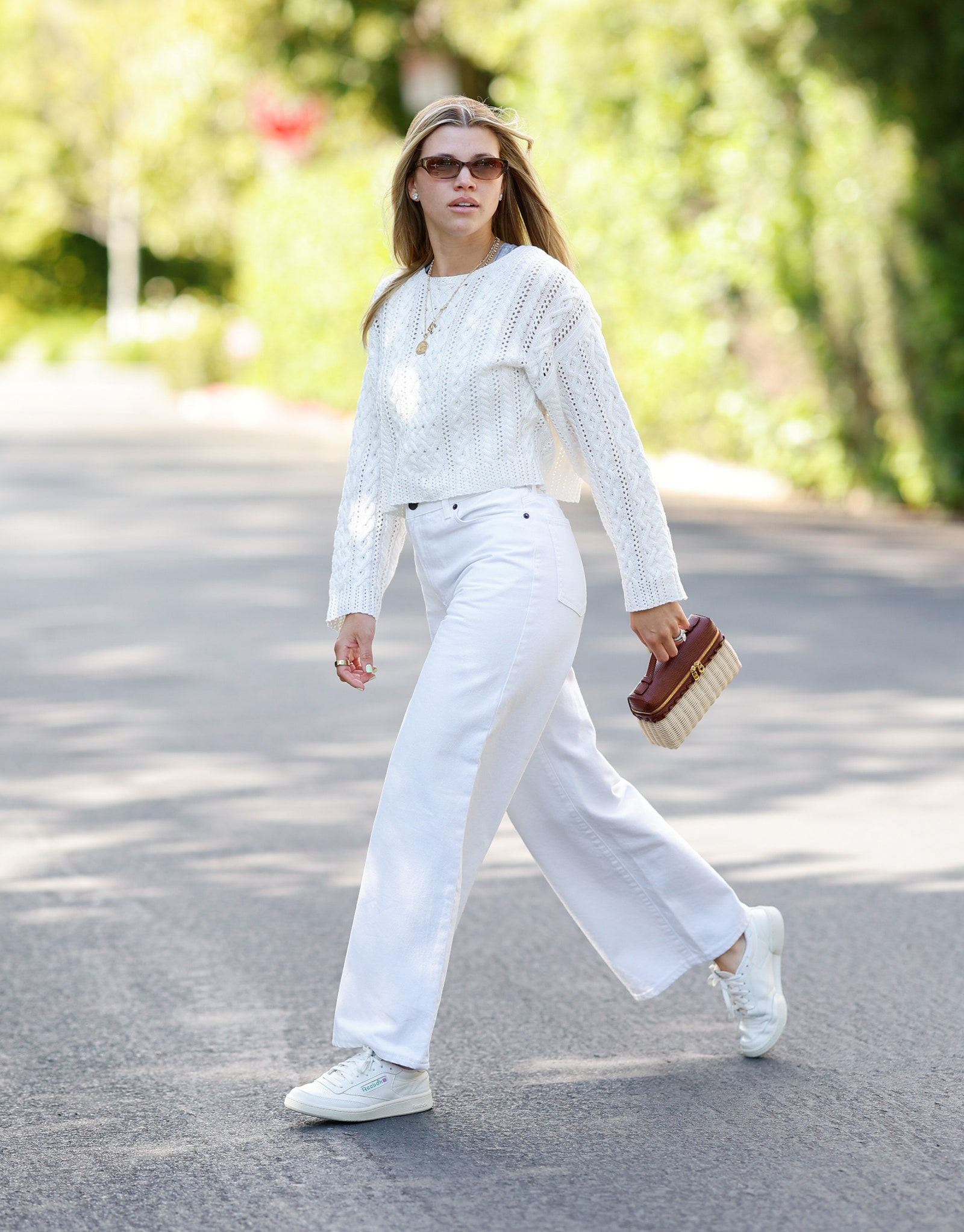 Images may contain Sofia Richie clothing pants men walking jeans pedestrian accessories jewelry and necklace