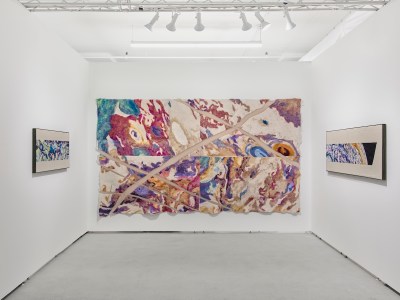 The large-scale abstract fiber tapestry center is an art fair stall with two smaller works on both sides