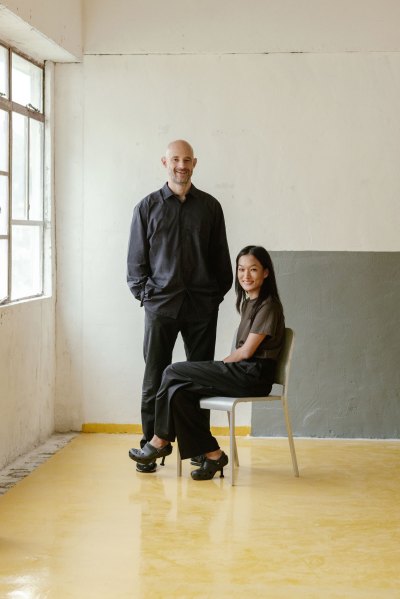 Portraits of Edouard Malingue and Lorraine Kiang. He stood, and she sat on the gray chair to her right. 