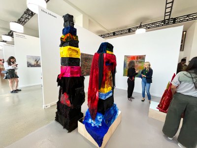 Two totem sculptures made of various dyed fabrics, they are wrapped in boxes of different sizes. Some works are covered in works.