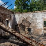 A man stands in the ruins of a bombed house in Ukraine.