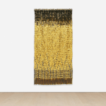 Golden wall hangs on a white wall.