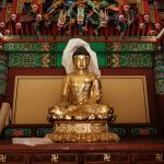 A golden statue of a lady with legs crossed.