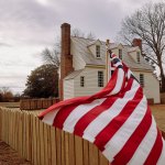 American flag waves in front of a small school.