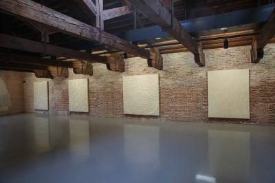 A set of abstract paintings hanging on the wall.