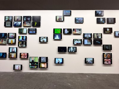 Dozens of small screens are installed on the wall at different intervals.