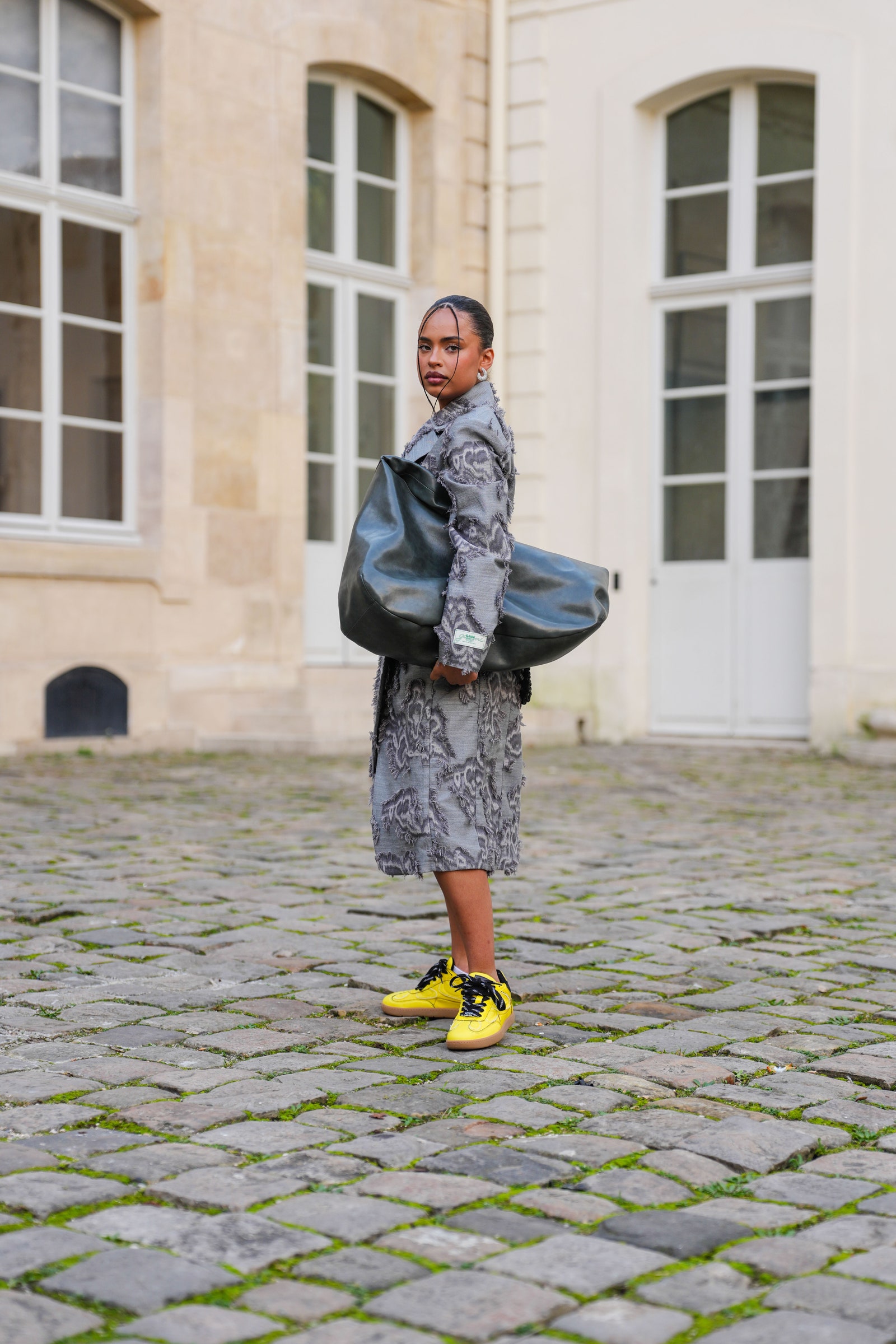 Image may contain clothing shoes and shoes adult standing pedestrian accessories bag and handbag