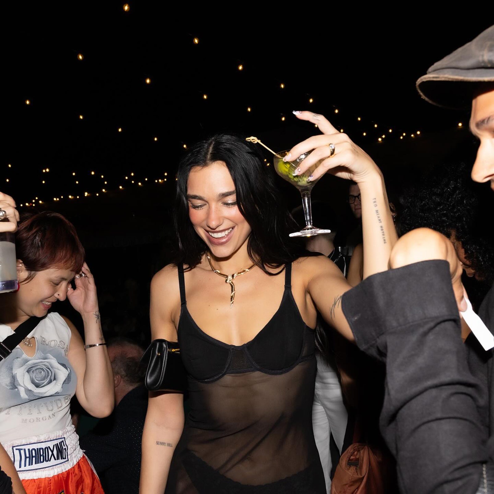 Image may contain dua lipa accessories jewelry necklace city clothing hat adult children rings and wedding