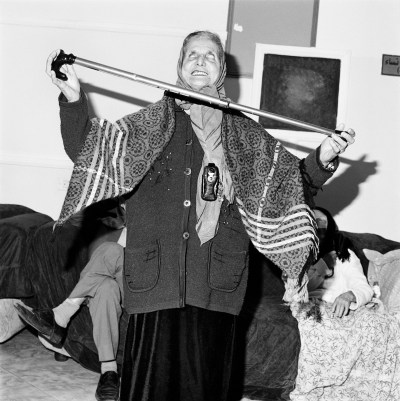 A woman wearing a headscarf balances crutches between her hands.