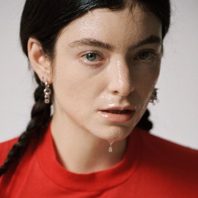 A woman with long braids in a red shirt. There was a translucent substance on her face.