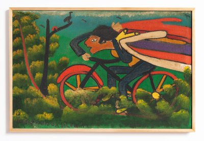 A man with a cape rides a bicycle in a lush landscape. 
