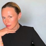 A white white woman wearing a black long-sleeved top looking at the camera.
